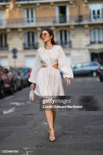 Ketevan Giorgadze @katie.one wears oversized sunglasses by For Art’s Sake, a gold chain necklace by For Art’s Sake, a white cut out mini dress with...