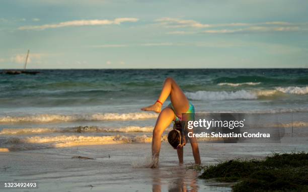 flexible graceful little girl doing artistic contortion on scene diani beach, indian ocean, kenya. - vacancy stock pictures, royalty-free photos & images