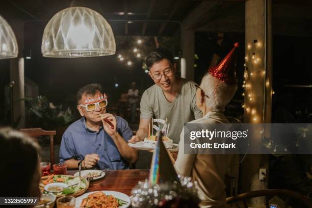 happy birthday to you, son wishing his mother luck-stock photo - man giving cake candle stock pictures, royalty-free photos & images