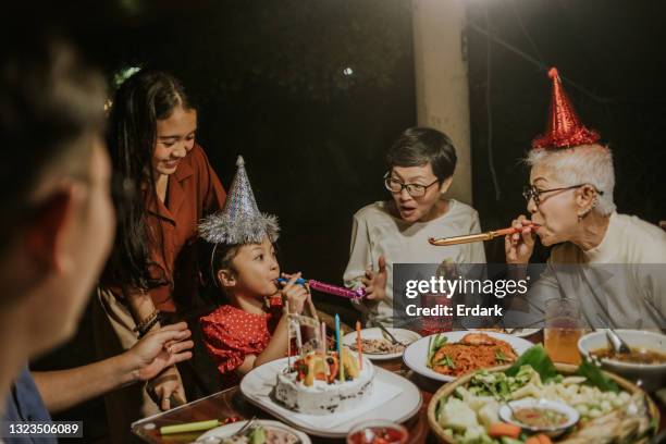 soffiando gioco giocattolo con contrasto età dopo festa di compleanno- foto d'archivio - parents children blow candles asians foto e immagini stock