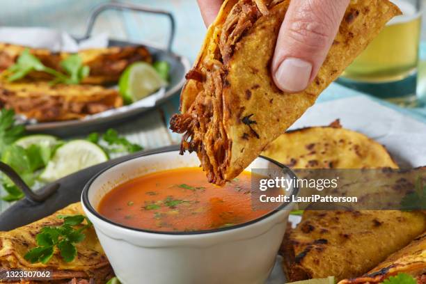 crispy fried birria tacos - dipping sauce stock-fotos und bilder
