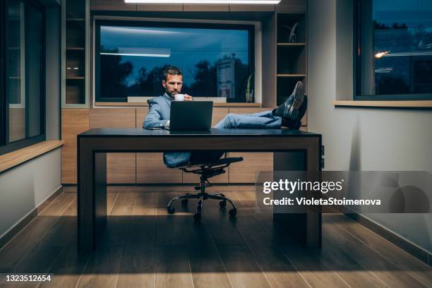 affärsman som använder bärbar dator på kontoret. - legs on desk bildbanksfoton och bilder