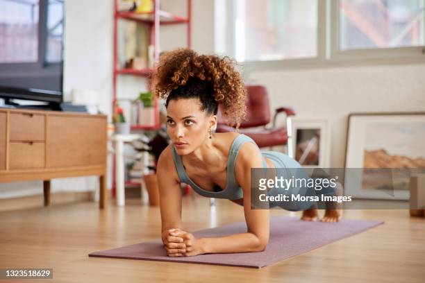 fit woman wearing sportswear practicing yoga - muscle photos et images de collection