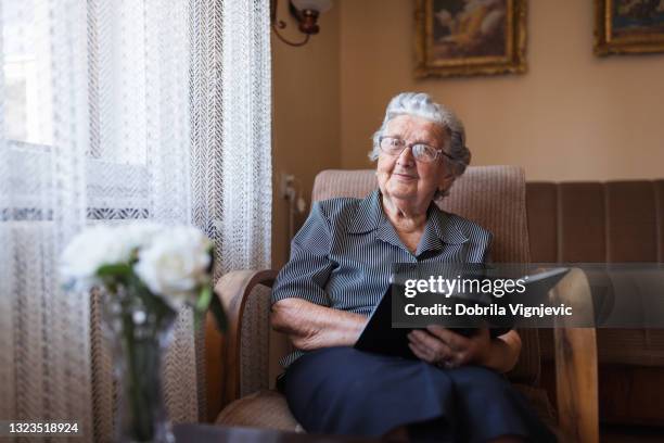 grandmother reading a book at home - nostalgie stock pictures, royalty-free photos & images