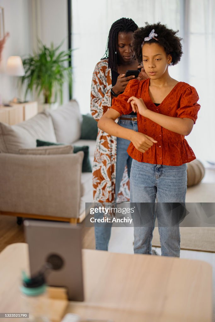 Mutter und Tochter aufnehmen ein Tanzvideo zu Hause