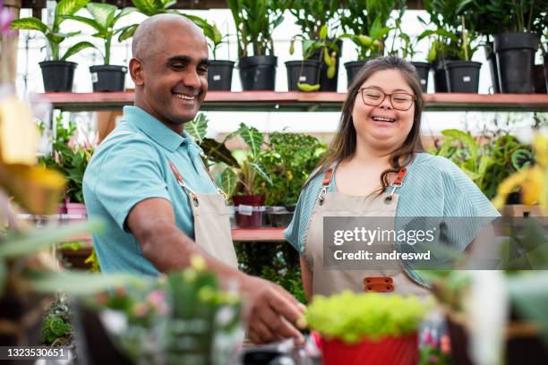 sociale integratie - vrouw met downsyndroom die in kleine zaken werkt - down syndrome care stockfoto's en -beelden