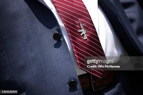 Rep. Andrew Clyde wears a tie pin in the shape of a firearm as he listens to a question from a reporter during a press conference held with Rep....