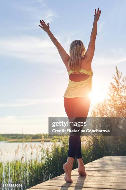 a beautiful 45-year-old woman in sports clothes threw her arms out to the sides in nature with her back to the camera. - 45 49 år bildbanksfoton och bilder