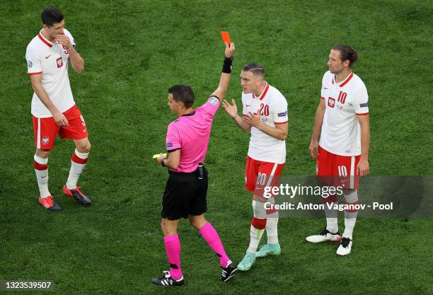 Grzegorz Krychowiak of Poland is shown a red card by Match Referee, Ovidiu Hategan as Piotr Zielinski of Poland protests during the UEFA Euro 2020...