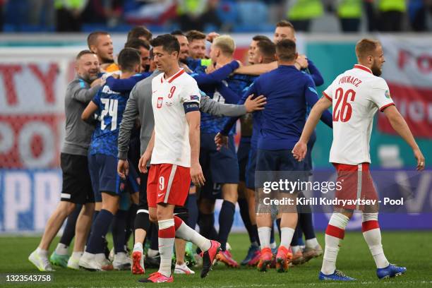 Robert Lewandowski of Poland looks dejected as Players of Slovakia celebrate after victory in the UEFA Euro 2020 Championship Group E match between...