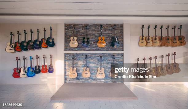 guitars hanging display on wall for sale - guitar shop stock pictures, royalty-free photos & images