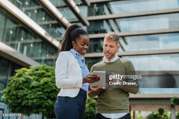 adult diverse business people in financial district outdoors - teamwork in sustainable environment - environmental building stockfoto's en -beelden