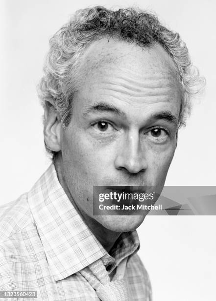 Portrait of playwright Jonathan Reynolds in front of a white background, July 1981.