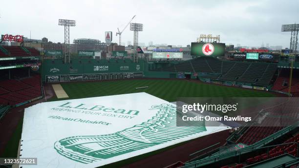 The tarp covers the field before the game between the Boston Red Sox and the Toronto Blue Jays at Fenway Park on June 14, 2021 in Boston,...