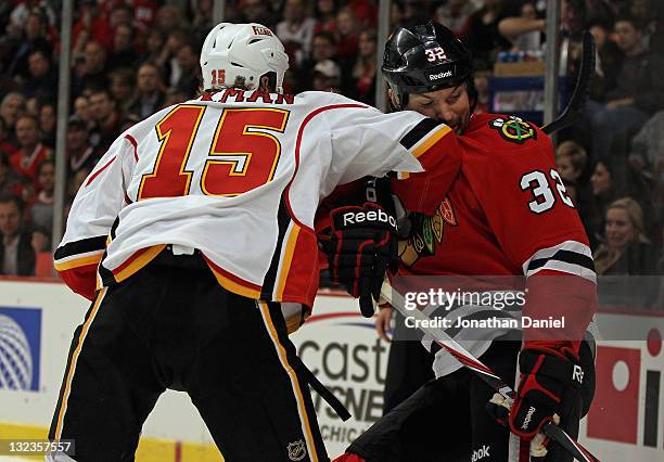 John Scott of the Chicago Blackhawks takes an elbow to the face from Tim Jackman of the Calgary Flames at the United Center on November 11, 2011 in...