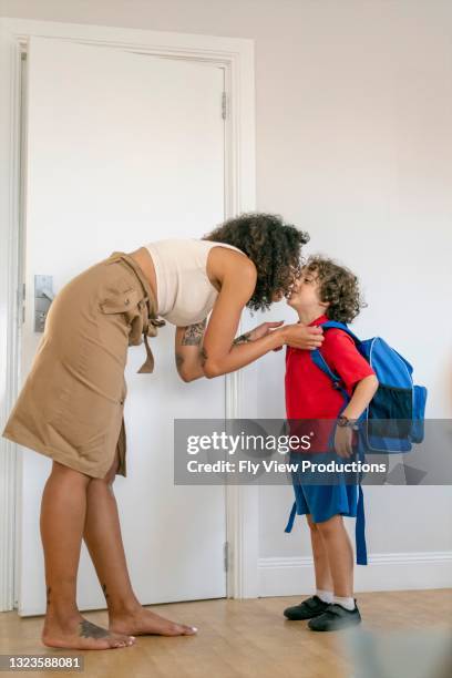 a beautiful ethnic mother kisses her son good-bye as he heads to school for the day - first day of school australia stock pictures, royalty-free photos & images