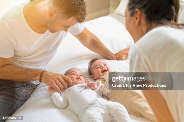 new mother and father dote over their newborn twins - twin stock pictures, royalty-free photos & images