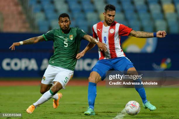 Adrian Jusino of Bolivia competes for the ball with Gabriel Avalos of Paraguay during a Group A match between Paraguay and Bolivia at Estádio...