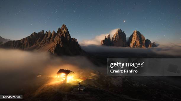 mountains with clouds, stars and village - star hotel stock pictures, royalty-free photos & images