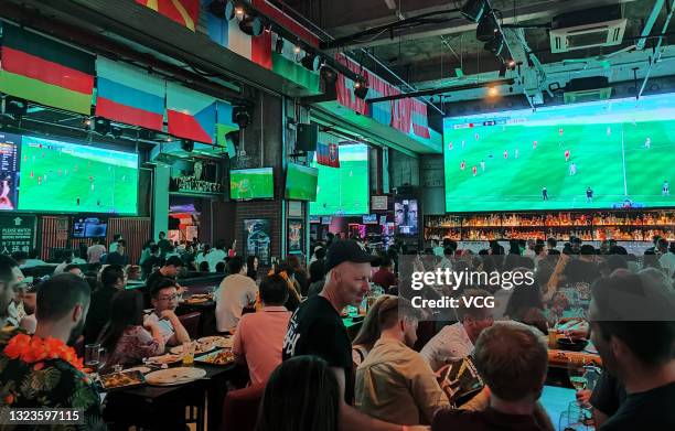 Football fans watch UEFA Euro 2020 Championship Group A match between Wales and Switzerland at a pub on June 12, 2021 in Shanghai, China.