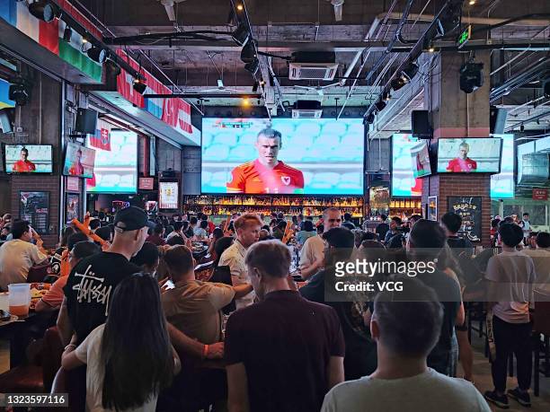 Football fans watch UEFA Euro 2020 Championship Group A match between Wales and Switzerland at a pub on June 12, 2021 in Shanghai, China.