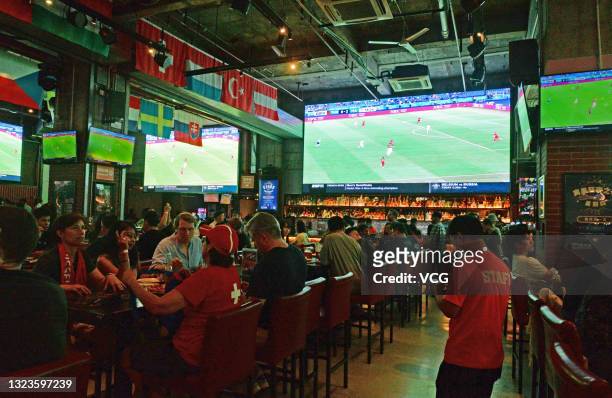 Football fans watch UEFA Euro 2020 Championship Group A match between Wales and Switzerland at a pub on June 12, 2021 in Shanghai, China.