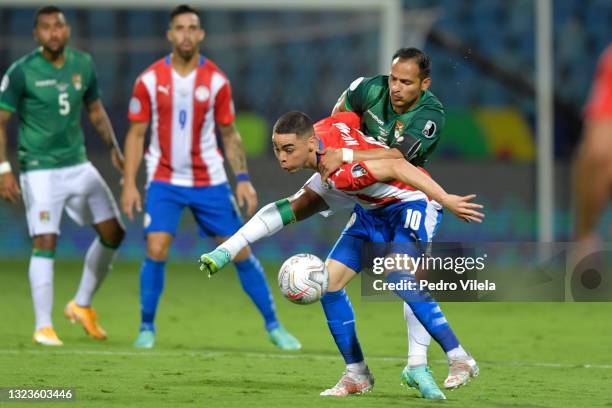 Miguel Almiron of Paraguay competes for the ball with Leonel Justiniano of Bolivia during a Group A match between Paraguay and Bolivia at Estádio...