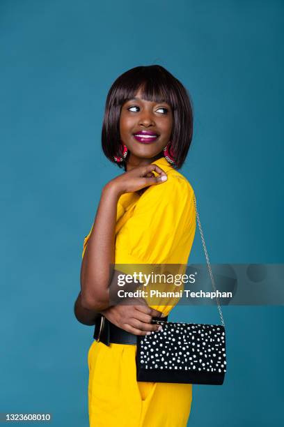 beautiful woman in yellow outfit - black purse fotografías e imágenes de stock