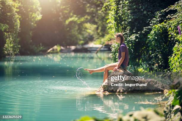 teenage girl resting on a rock in river elsa in tuscany, italy - água doce imagens e fotografias de stock