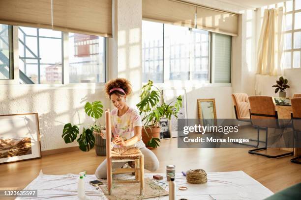 woman with paint upcycling chair at home - home maintenance stock pictures, royalty-free photos & images