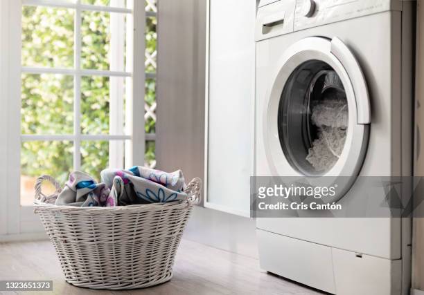 laundry room with washing machine and laundry basket - washing basket stock-fotos und bilder