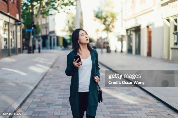 young woman searching for directions using navigation app on smart phone - missing photos et images de collection