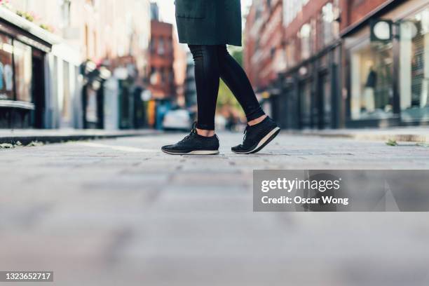 close-up of female feet walking down city street - människofot bildbanksfoton och bilder