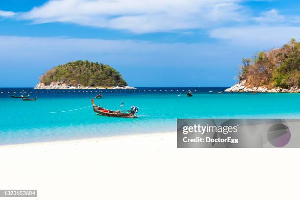 fisherman long tail boats in turquoise andaman sea in summer and white sand beach of kata beach, phuket, thailand - phuket ストックフォトと画像