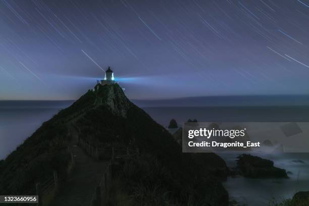 nugget point lighthouse at night, new zealand - nugget point stock pictures, royalty-free photos & images