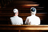 Jewish men sitting together and praying inside synagogue