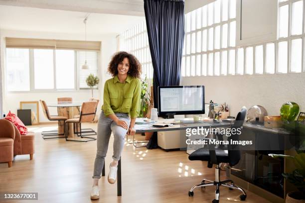 female freelancer sitting on desk at home office - smart casual stock pictures, royalty-free photos & images