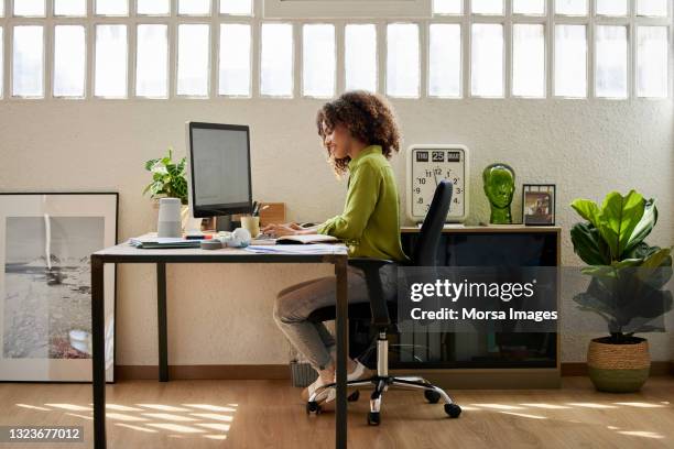 female professional using computer at home office - silla de oficina fotografías e imágenes de stock