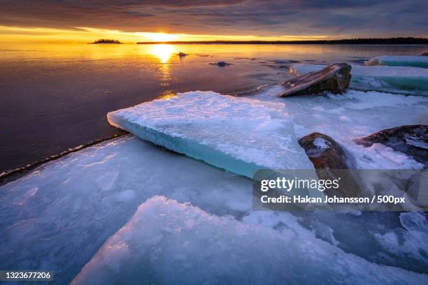 scenic view of frozen sea against sky during sunset,sweden - soluppgång stockfoto's en -beelden