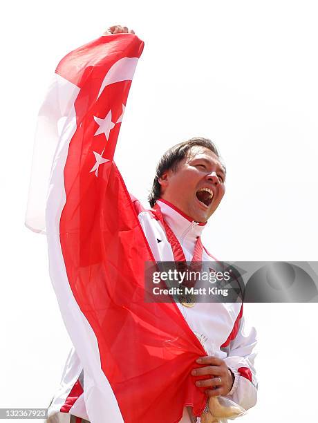 James Wong of Singapore celebrates at the medal ceremony after winning the Mens Discus on day two of the 2011 Southeast Asian Games at Jakabaring...