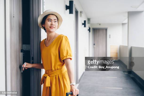 young asian woman in yellow dress open her room while arrival at hotel. - yellow dress stock pictures, royalty-free photos & images