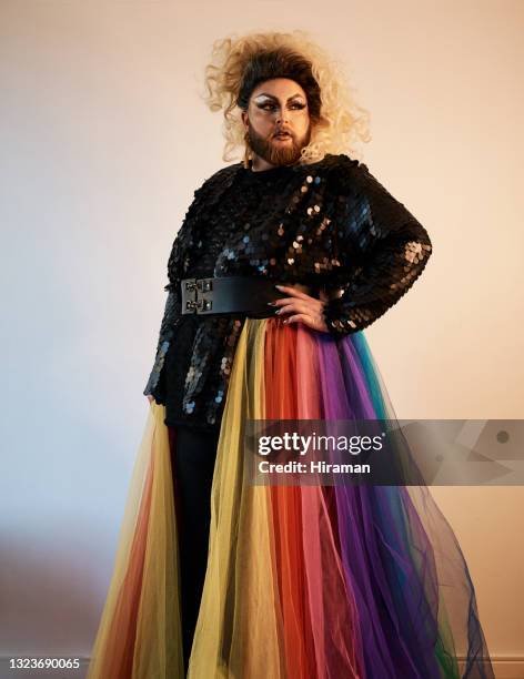 shot of a young man posing against a wall in a studio - travesti imagens e fotografias de stock