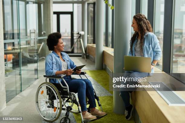disabled computer programmer discussing with female coworker in office hallway - programmer working stock pictures, royalty-free photos & images