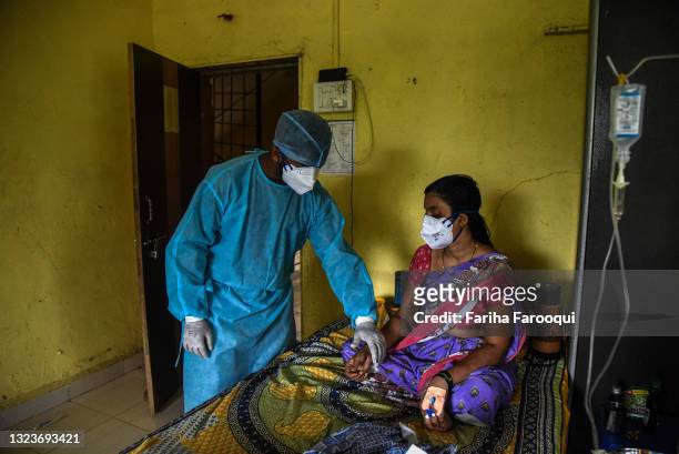 Pradip Salave Shramajeevi, a healthcare worker, checks on his patients inside a school which has been converted into a Covid-19 care facility on June...