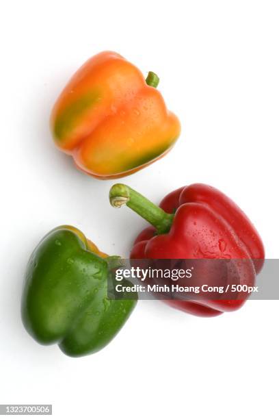 close-up of red bell peppers over white background,france - bell pepper stockfoto's en -beelden