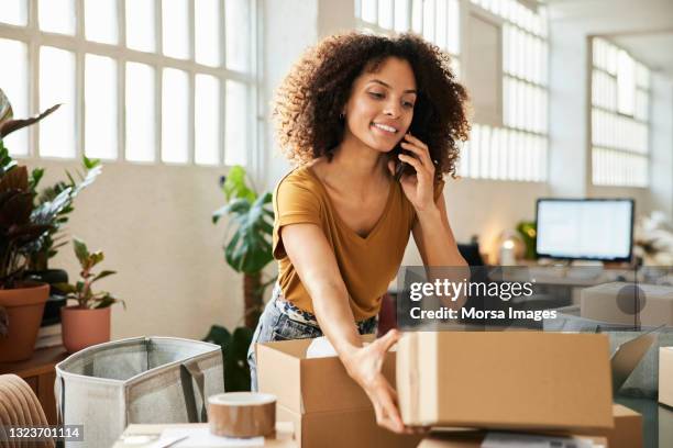 female entrepreneur with cardboard boxes at office - talk phone flat imagens e fotografias de stock