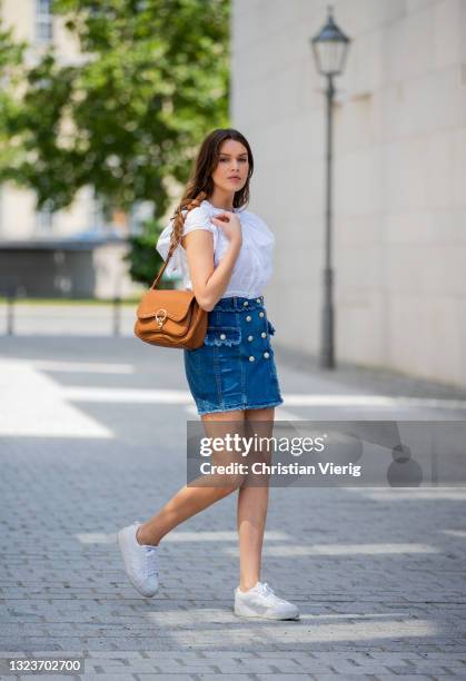 Giannina Haupt is seen wearing white blouse, denim mini skirt, brown bag Liu Jo on June 14, 2021 in Berlin, Germany.