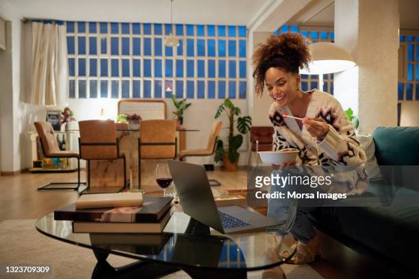 woman having dinner and watching movie at home - single adults eating dinner at home stock pictures, royalty-free photos & images