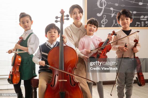 happy children's music lessons - girl cello stock pictures, royalty-free photos & images
