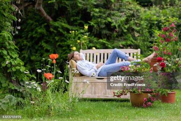 gartenarbeit - frau entspannen im garten - gartenanlage stock-fotos und bilder